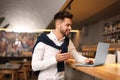 Young male business owner working with laptop at counter in cafe Royalty Free Stock Photo
