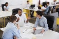 Young male business team brainstorming in busy office Royalty Free Stock Photo