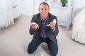 Young male businessman anger, hysterical kneeling on the floor, screaming and holding crumpled paper in his hands Royalty Free Stock Photo