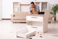 Young male carpenter repairing furniture at home