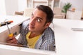 Young male carpenter repairing furniture at home