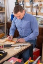 Young male carpenter working wood plank at workshop Royalty Free Stock Photo