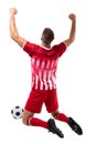 Young male caucasian athlete celebrating while kneeling by soccer ball over white background