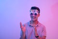 A young male celebrant clapping or giving applause. Wearing hilarious birthday novelty shades and having a good time. Lit with Royalty Free Stock Photo