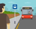 Young male character is waiting for city bus. Back view of a passenger at bus stop. Royalty Free Stock Photo