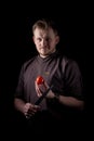 A chef in a uniform jacket shows off a professional chef`s knife and a tomato