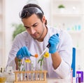 Young male chemist in perfume synthesis concept