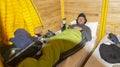 Young male climber resting on a bunk inside a mountain refuge