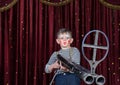 Young Male Clown Aiming Large Rifle on Stage Royalty Free Stock Photo