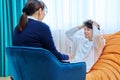 Young male communicates with female psychologist at therapy session in office Royalty Free Stock Photo