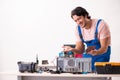 The young male contractor repairing computer Royalty Free Stock Photo