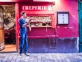 Young male cook twirls crepe pan in front of his creperie on Montmartre