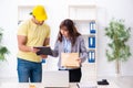 Young male courier delivering parcel to the office Royalty Free Stock Photo