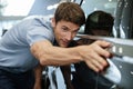 Young male customer examining a new car