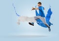 Young male dancer jumping with splash of paint Royalty Free Stock Photo