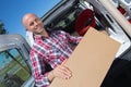 young male deliverer unloading boxes from car