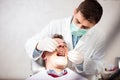 Young male dentist examining mature male patient, looking for caries