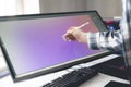 a young male digital artist drawing paint on the computer screen monitor in studio