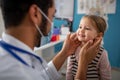 Young male doctor checking little girl& x27;s lymph nodes in his office. Royalty Free Stock Photo