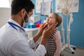 Young male doctor checking little girl's lymph nodes in his office. Royalty Free Stock Photo