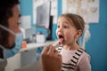 Young male doctor checking little girl's throat in his office. Royalty Free Stock Photo