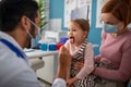 Young male doctor checking little girl's throat in his office. Royalty Free Stock Photo