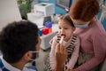 Young male doctor checking little girl's throat in his office. Royalty Free Stock Photo
