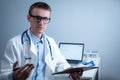 Young male doctor consults patient in hospital office, holding medical examinations in hands. General practitioner in Royalty Free Stock Photo