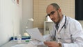 Young male doctor in glasses taking a phone call Royalty Free Stock Photo