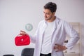 Young male doctor paramedic holding first aid bag