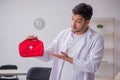 Young male doctor paramedic holding first aid bag