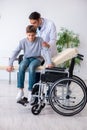 Young male doctor pediatrist and boy in wheel-chair