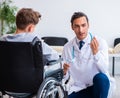 Young male doctor pediatrist and boy in wheel-chair