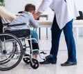 Young male doctor pediatrist and boy in wheel-chair