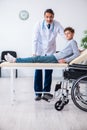 Young male doctor pediatrist and boy in wheel-chair