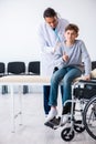 Young male doctor pediatrist and boy in wheel-chair