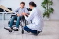 Young male doctor pediatrist and boy in wheel-chair