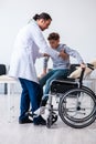 Young male doctor pediatrist and boy in wheel-chair