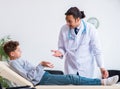 Young male doctor pediatrist and boy in wheel-chair