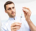 Young male doctor prepares a medicine into the syringe in the office.Doctor holding a syringe Royalty Free Stock Photo