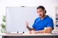 Young male doctor teacher dentist in front of whiteboard Royalty Free Stock Photo