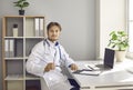 Portrait of young male doctor sitting at desk with laptop computer in his office Royalty Free Stock Photo