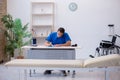 Young male doctor writing prescription in the clinic Royalty Free Stock Photo