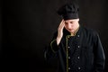 Young male dressed in a black chef suit has headache Royalty Free Stock Photo