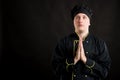 Young male dressed in a black chef suit praying Royalty Free Stock Photo