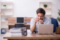 Young male drug addicted employee at workplace Royalty Free Stock Photo