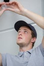 young male electrician fixing light on ceiling Royalty Free Stock Photo