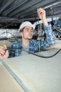 Young male electrician fixing light on ceiling Royalty Free Stock Photo