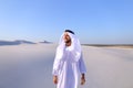 Young male emirate rejoices in life and walks through expanses o