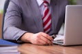 Young male employee inserting flash drive into laptop